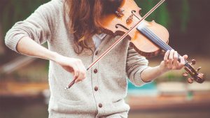 HUDBA - foto - dívka hraje na housle, v kategorii hudba nabízíme výuku hraní na hudební nástroje dle výběru, lekce sólového zpěvu, dirigování a hudební nauky.